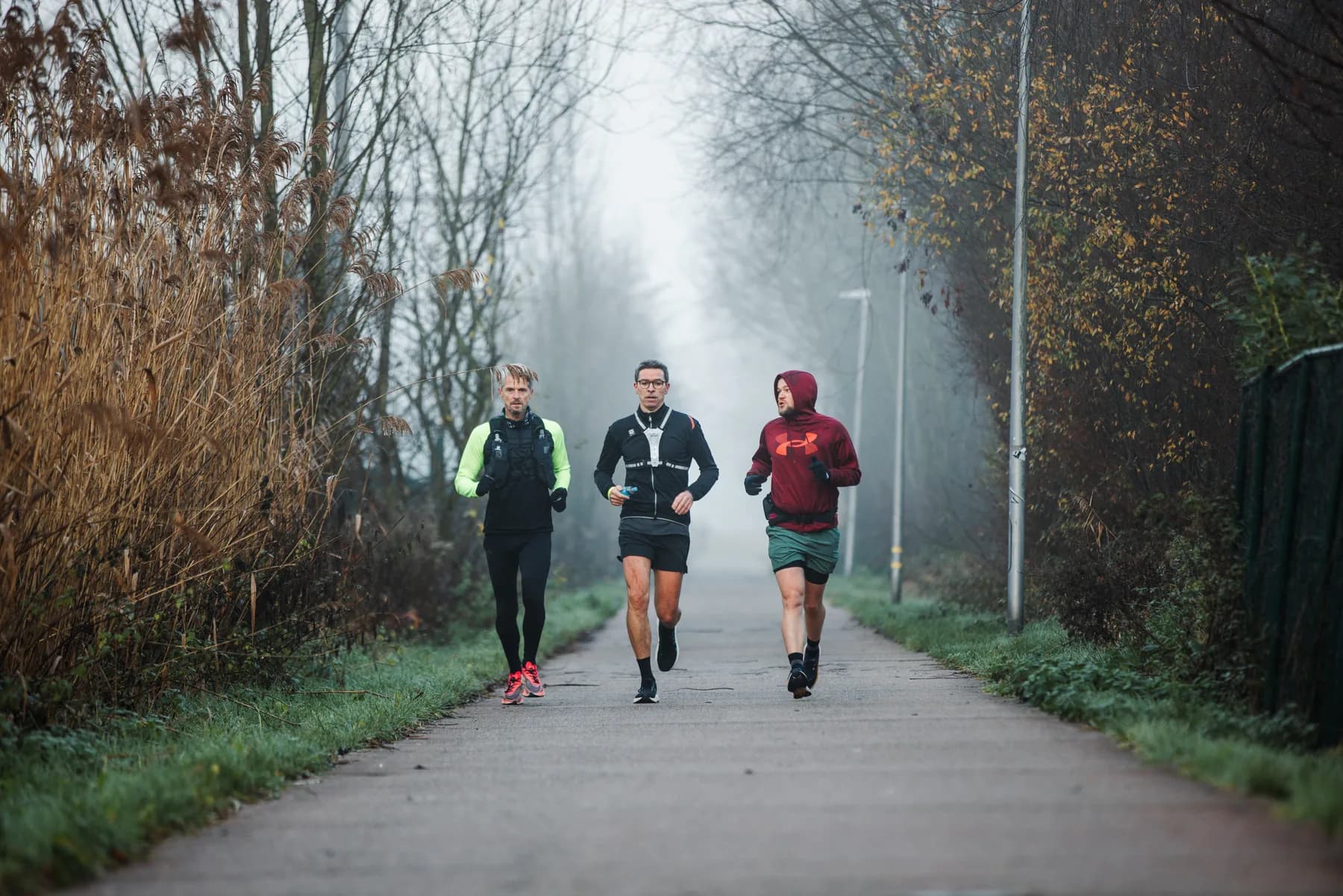 Drie lopers in de ochtendmist op het parcours van 2025